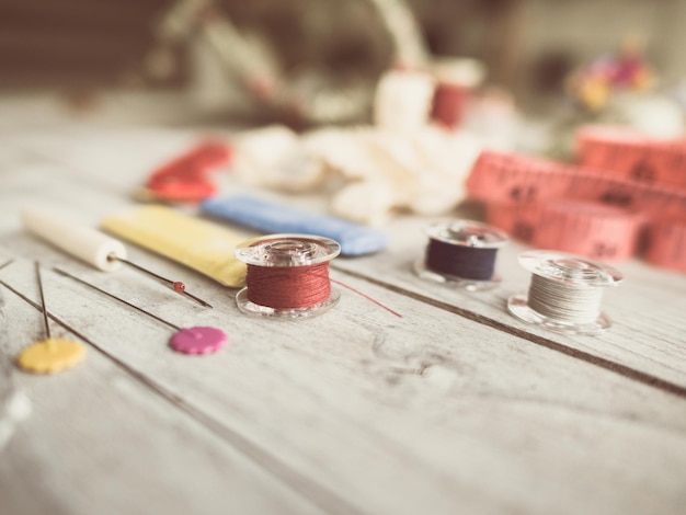 Ručná ihla a farebné nite na stoloch dielne